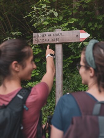 Escursionisti indicano il cartello escursionistico | © Notdurfter Anna - TV Antholzertal