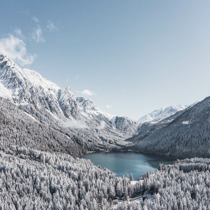Lago ghiacciato, sfondo di montagna, bosco | © Kottersteger Manuel - TV Antholzertal