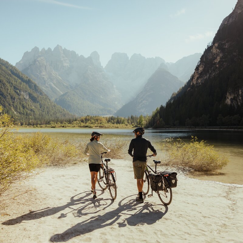 Due ciclisti in piedi al Lago di Landro | © IDM Südtirol - Alex Molling